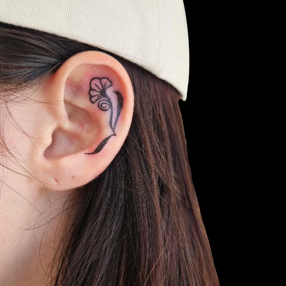 Fine line flower tattooed inside the ear