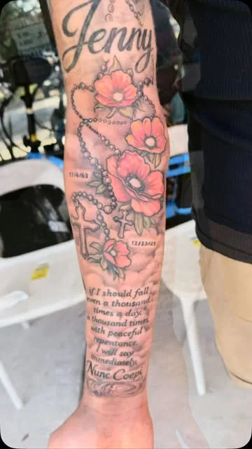 Poppies and script lettering wrapping a forearm