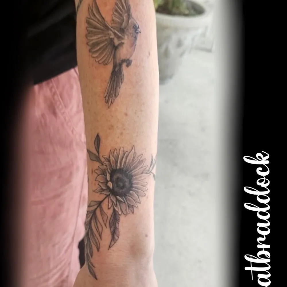 Swallow and sunflower running down a forearm